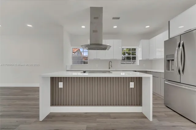 a kitchen with stainless steel appliances granite countertop a refrigerator a sink and a stove