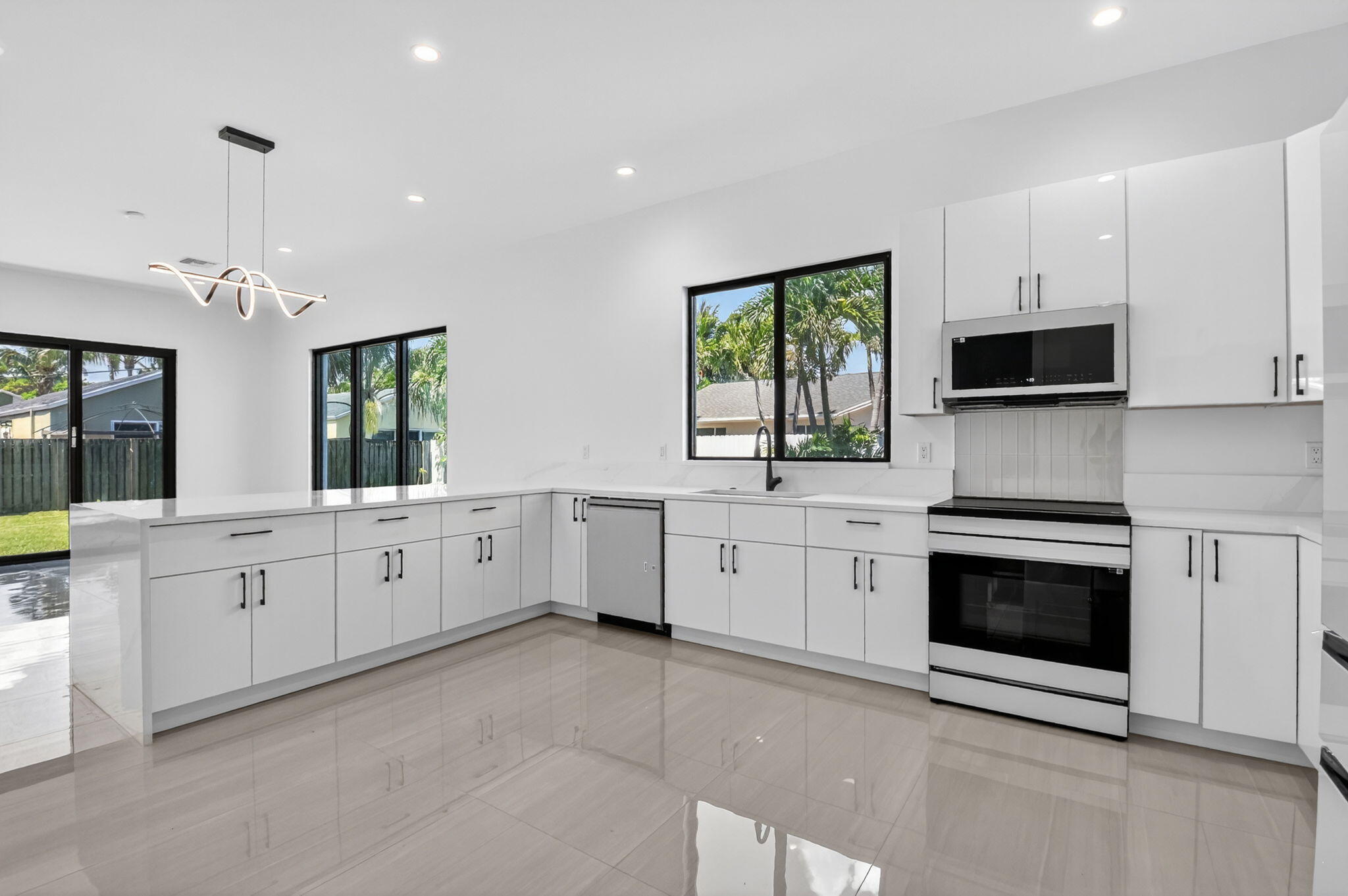 3920 Espan Court Palm Springs, FL 33461 - Photo 16 of 51 a large white kitchen with granite countertop lots of white stainless steel appliances