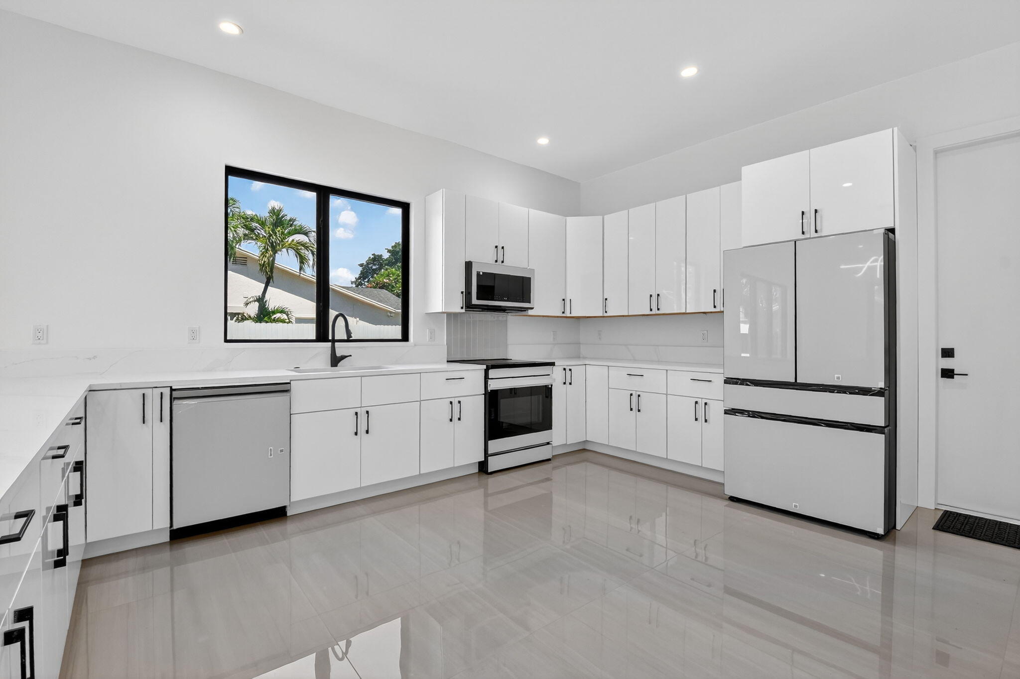 3920 Espan Court Palm Springs, FL 33461 - Photo 18 of 51 a kitchen with white cabinets and white appliances