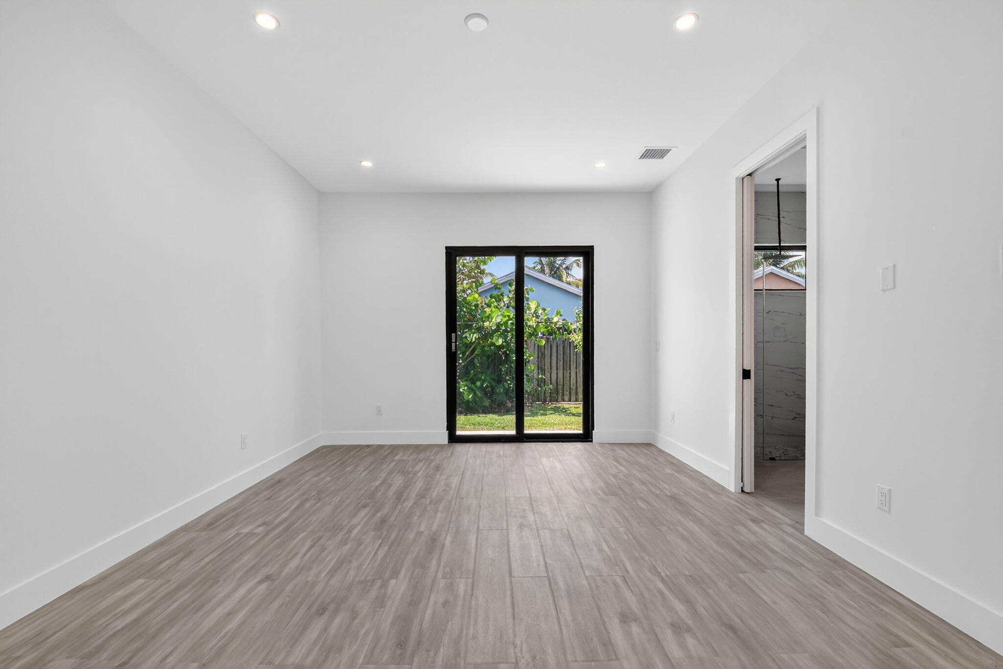 3920 Espan Court Palm Springs, FL 33461 - Photo 22 of 51 a view of an empty room with wooden floor and a window