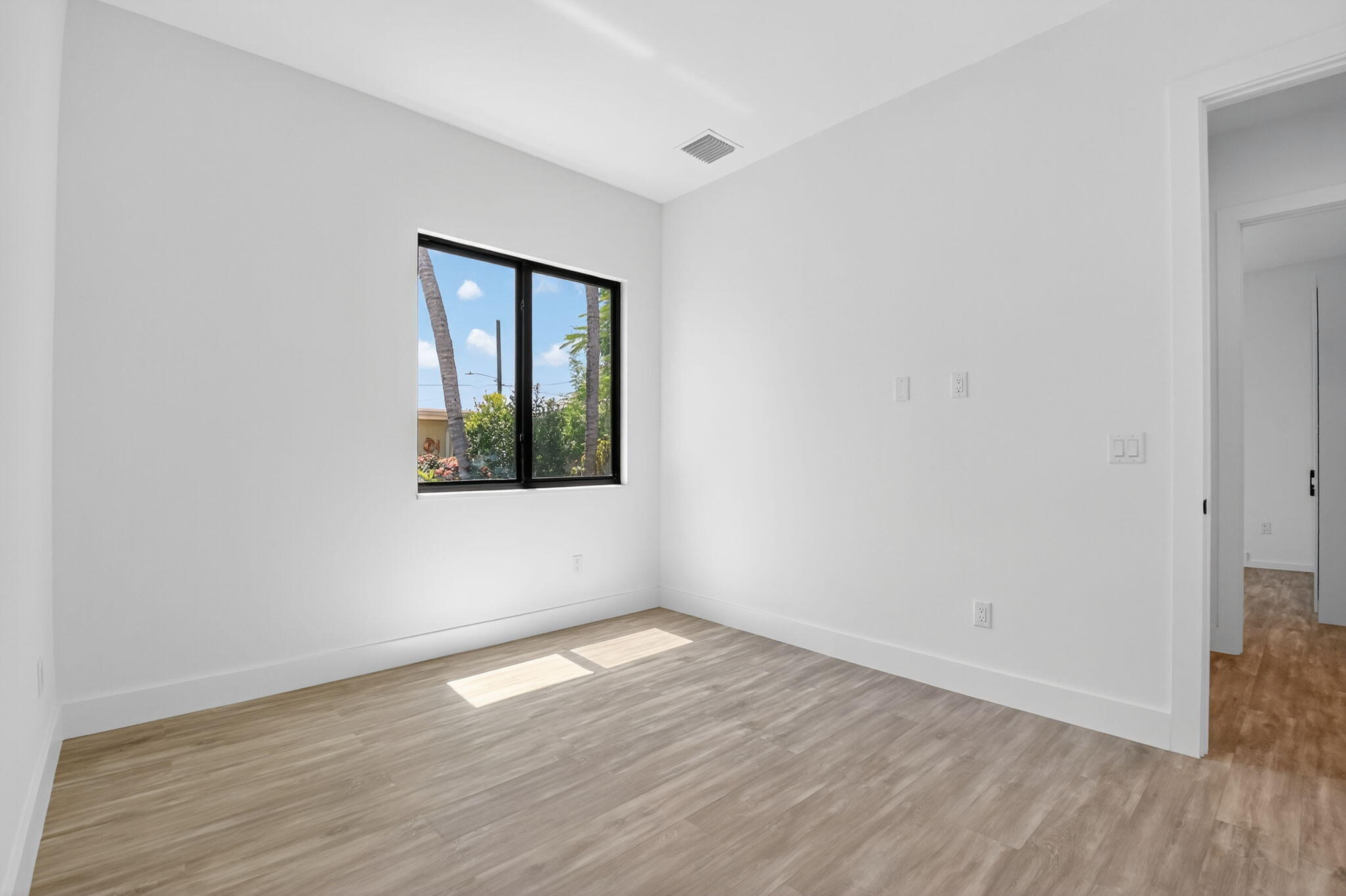 3920 Espan Court Palm Springs, FL 33461 - Photo 32 of 51 an empty room with wooden floor and windows