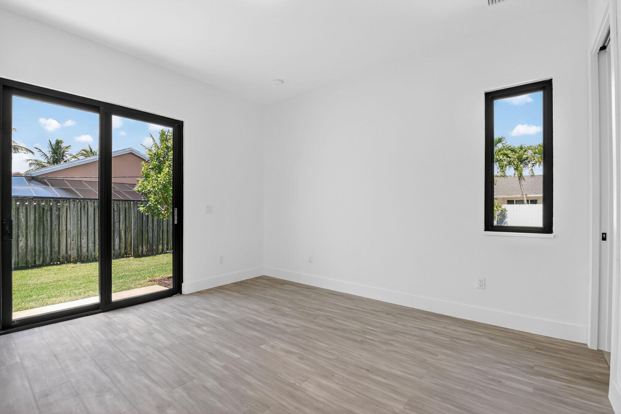 3920 Espan Court Palm Springs, FL 33461 - Photo 38 of 51 a view of an empty room with wooden floor and a window