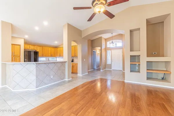 a view of a livingroom with wooden floor and a ceiling fan