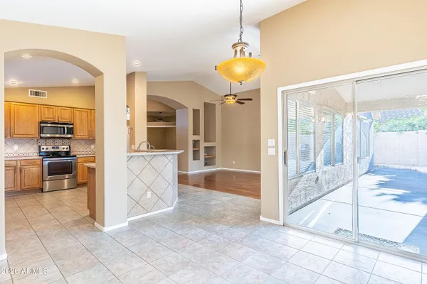 a view of a kitchen with kitchen island granite countertop a refrigerator and a sink