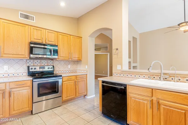 a kitchen with stainless steel appliances granite countertop a stove a sink and a microwave