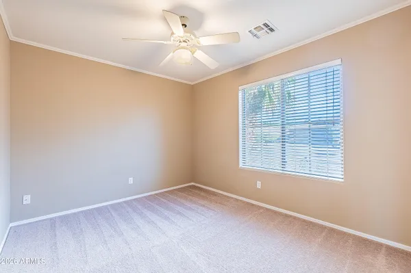 an empty room with a window and a fan