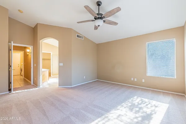a view of a big room with windows and chandelier fan