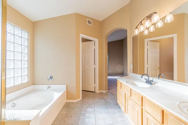 a spacious bathroom with a tub sink shower and mirror