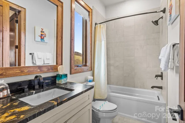 a bathroom with a granite countertop toilet sink and mirror
