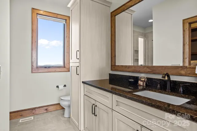 a kitchen with granite countertop white cabinets and window