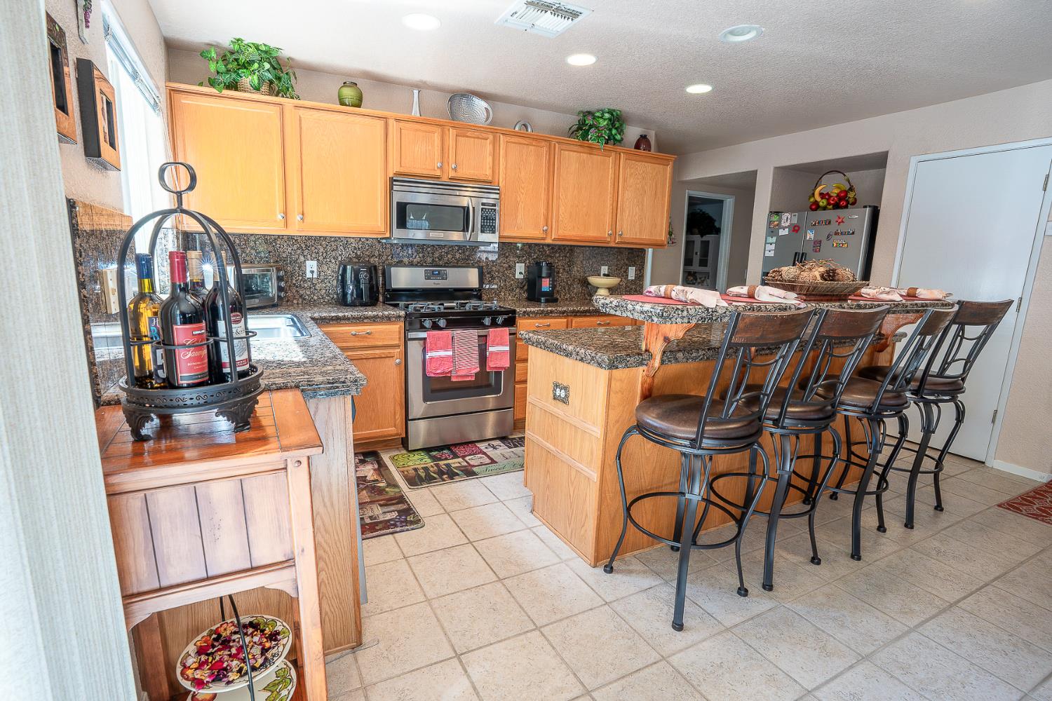 4237 Narraganset Way Mather, CA 95655 - Photo 7 of 40 a kitchen with stainless steel appliances kitchen island granite countertop a table chairs microwave and sink