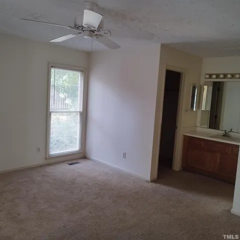 an empty room with windows and cabinet