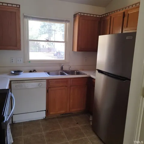 a kitchen with a sink a refrigerator a window and a cabinets