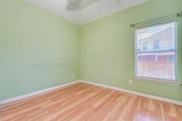 a view of a room with wooden floor and a window