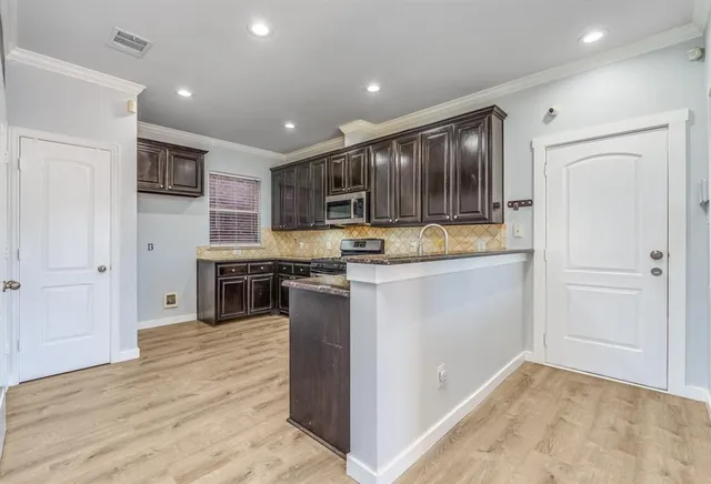 a kitchen with stainless steel appliances granite countertop a refrigerator and a stove
