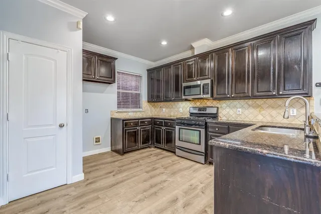 a kitchen with granite countertop stainless steel appliances and wooden cabinets