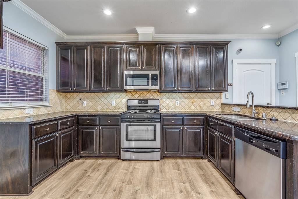 2300 Janna Way Carrollton, TX 75006 - Photo 19 of 40 a kitchen with a sink stove and cabinets