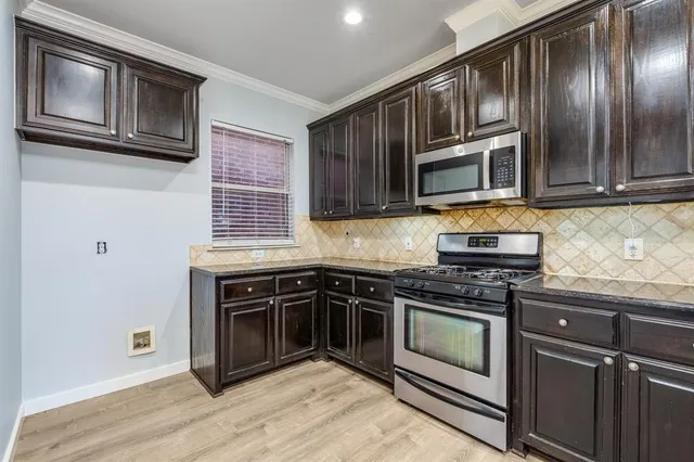 a kitchen with granite countertop cabinets stainless steel appliances and wooden floor