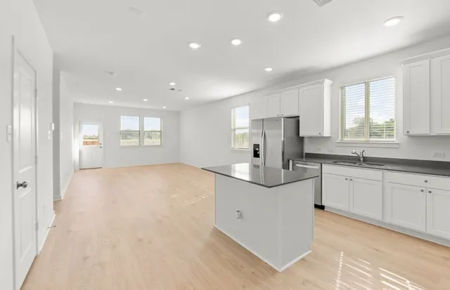 a kitchen with white cabinets and stainless steel appliances