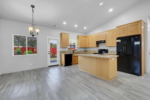 a kitchen with stainless steel appliances granite countertop a sink stove and cabinets