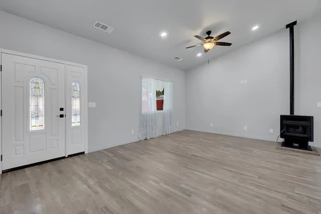 an empty room with chandelier fan