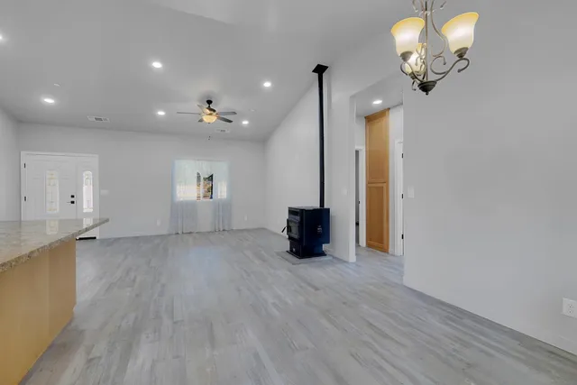 an empty room with a window and a fan