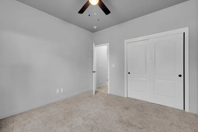 a bedroom with a bed a dresser and wooden floor