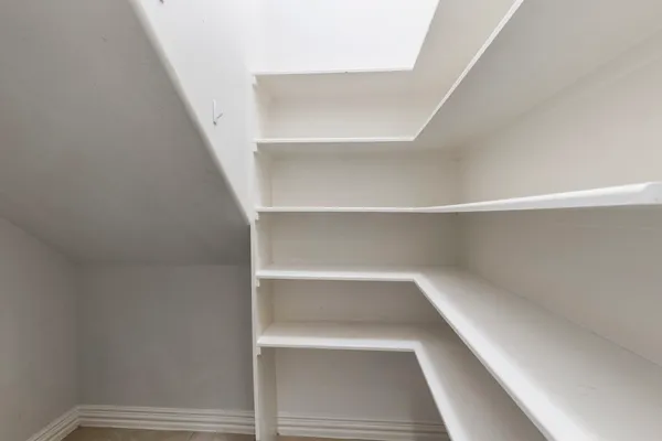 a view of walk in closet with empty racks