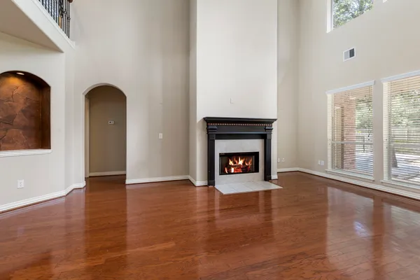 a view of an empty room with glass door and wooden floor