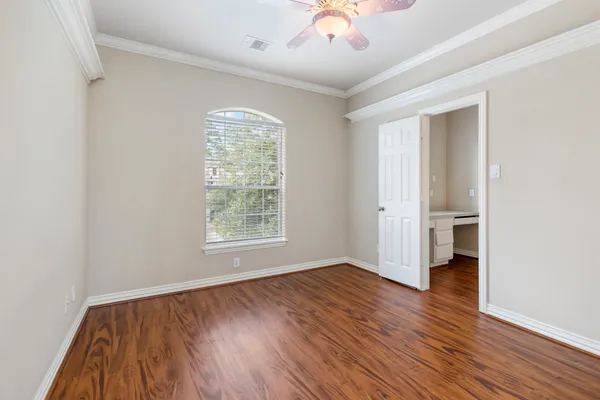 an empty room with wooden floor and a window