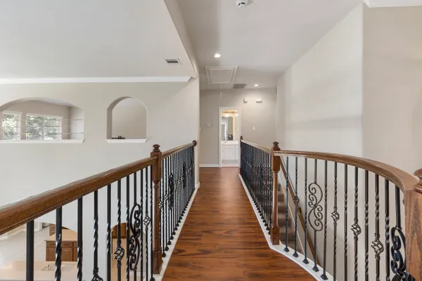 a view of a hallway with wooden floor and stairs