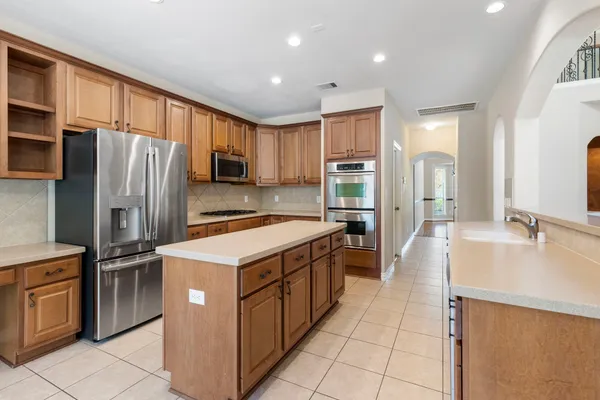 a kitchen with kitchen island granite countertop a sink stove and refrigerator