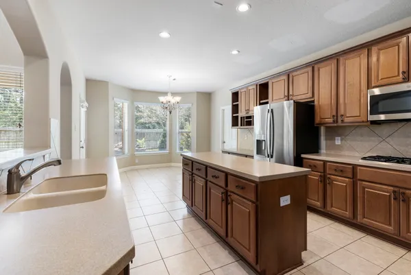 a kitchen with stainless steel appliances granite countertop a stove top oven a refrigerator a sink and dishwasher