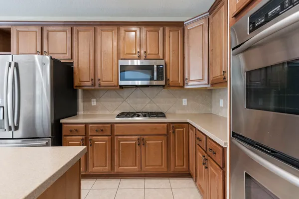 a kitchen with granite countertop a refrigerator stove and microwave