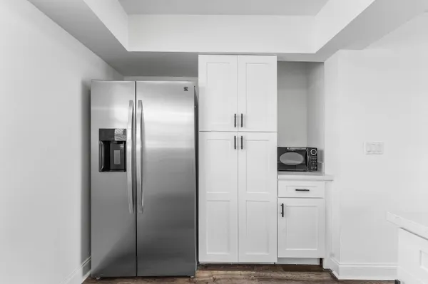 a view of kitchen with refrigerator cabinets and wooden floor