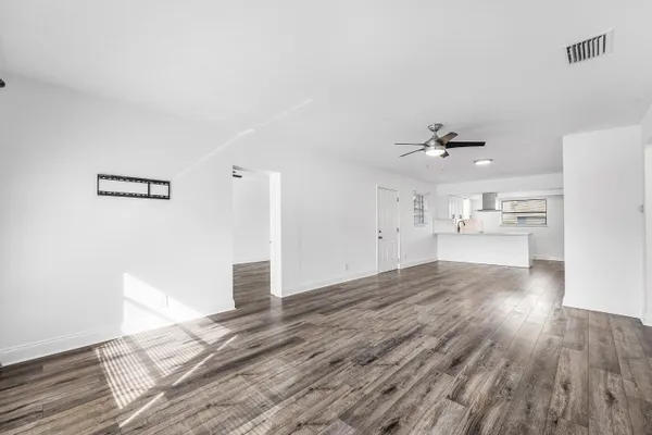a view of empty room with wooden floor