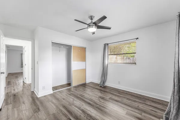 a view of empty room with wooden floor