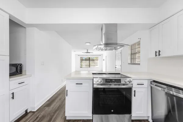 a kitchen with cabinets stainless steel appliances and wooden floor