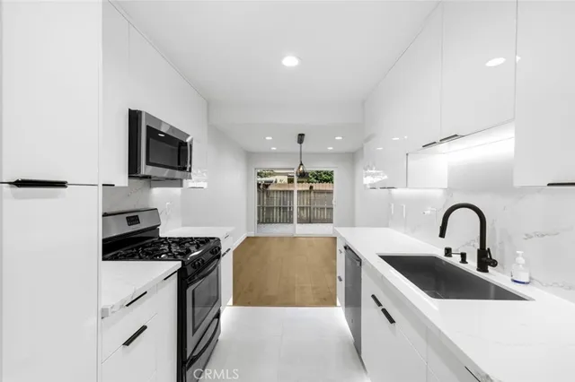 a kitchen that has a sink and a stove top oven