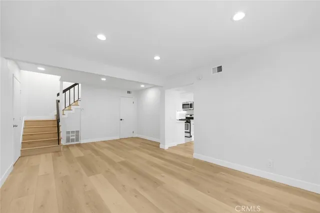 a view of empty room with wooden floor
