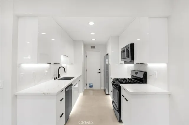 a kitchen with a sink a stove and cabinets