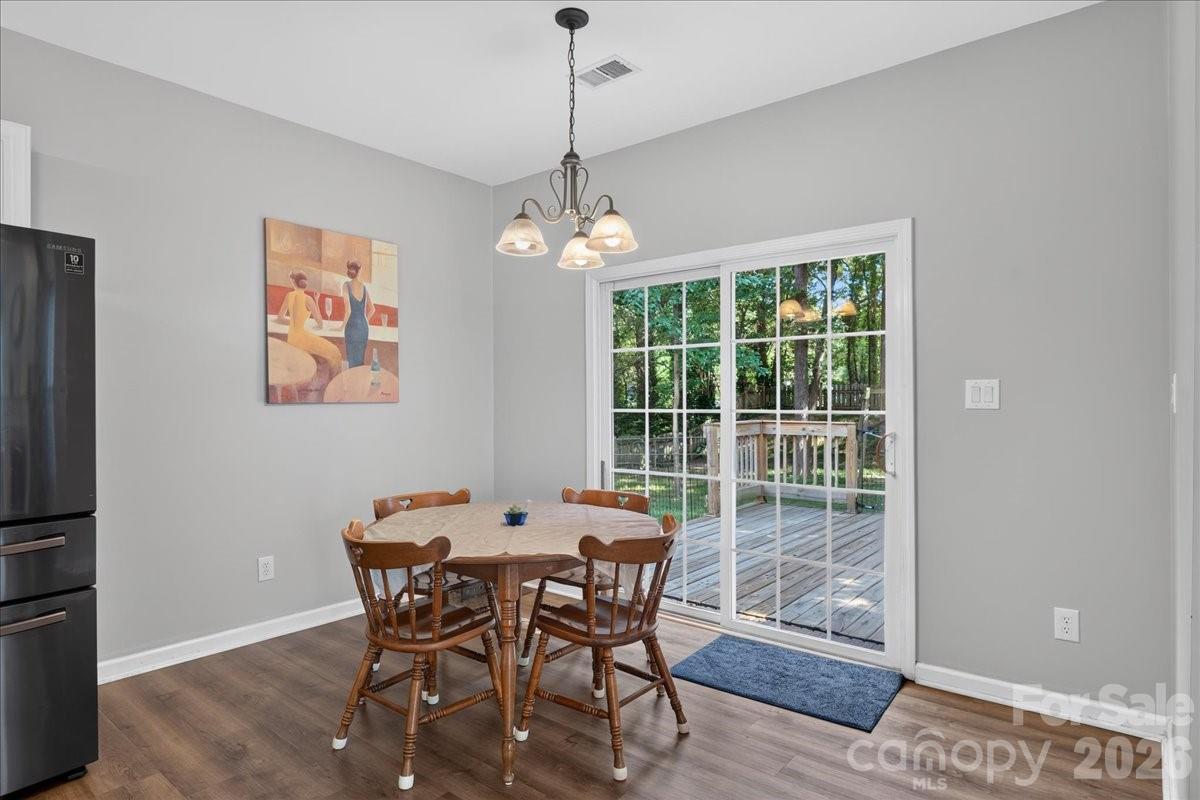 8006 Fine Robe Drive Indian Trail, NC 28079 - Photo 15 of 36 a dining room with furniture a chandelier and wooden floor