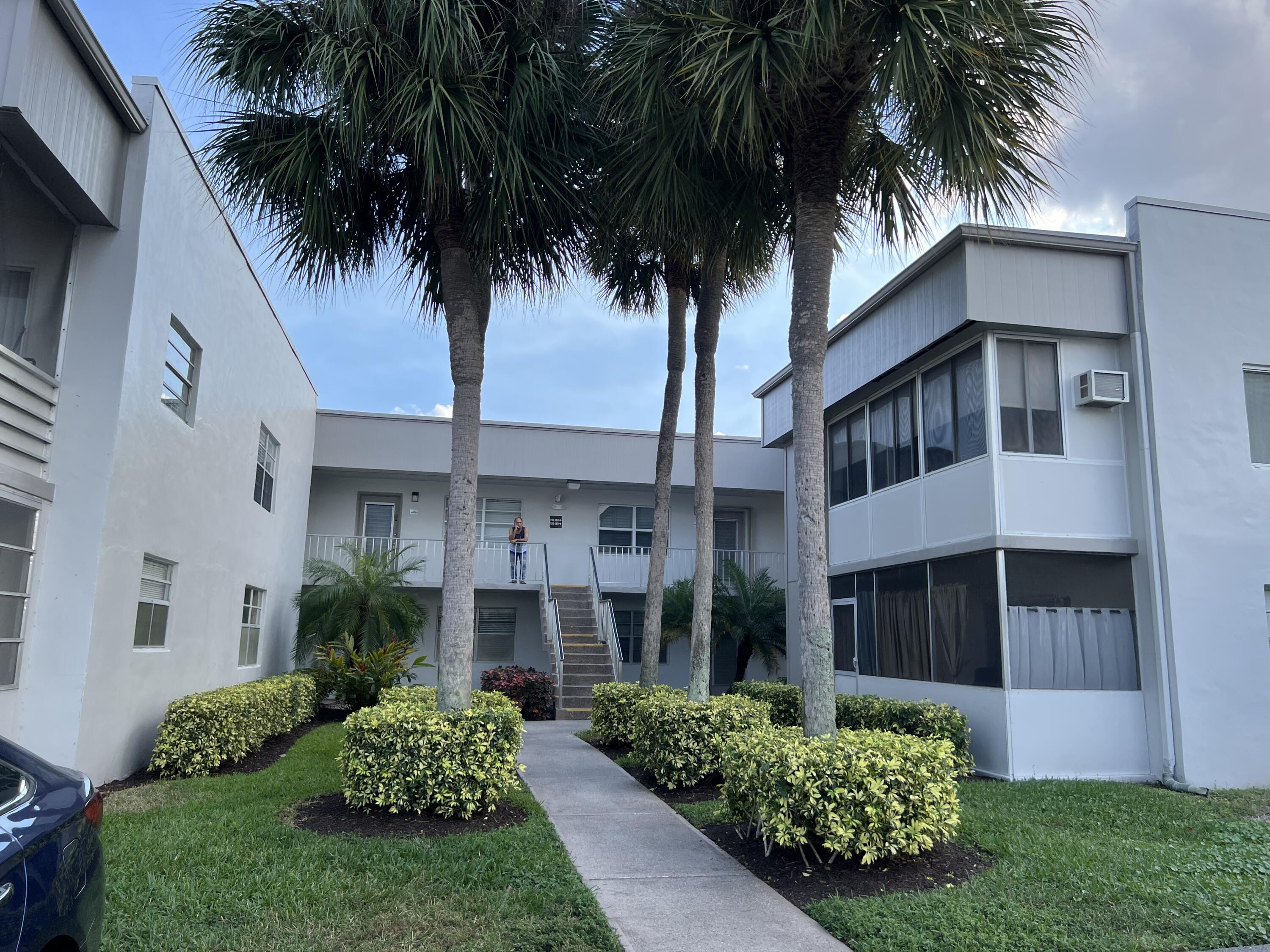 183 Normandy Lane Delray Beach, FL 33484 - Photo 47 of 80 a front view of a house with a garden and palm trees