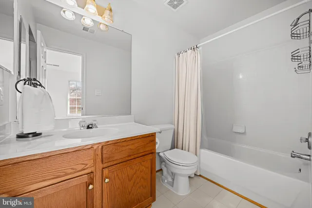 a bathroom with a granite countertop sink a toilet and shower