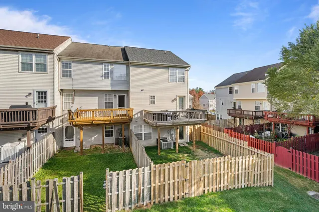 a view of a house with wooden deck and furniture
