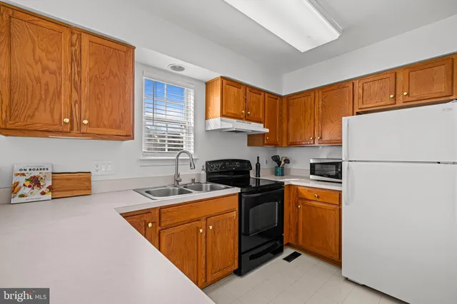 a kitchen with stainless steel appliances granite countertop a stove a sink dishwasher and a refrigerator