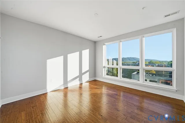 a view of an empty room with wooden floor