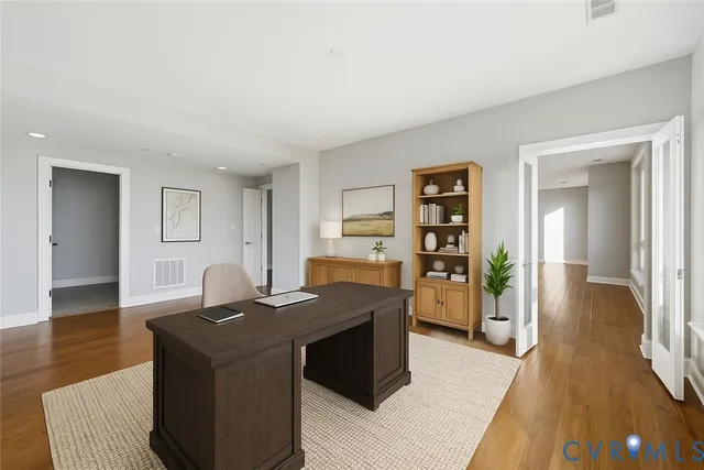 a view of a workspace with furniture and wooden floor