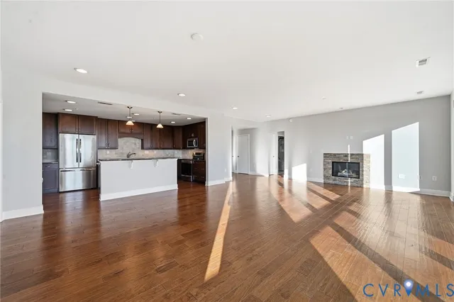 a kitchen with kitchen island granite countertop stainless steel appliances a refrigerator a sink a stove a microwave and wooden cabinets