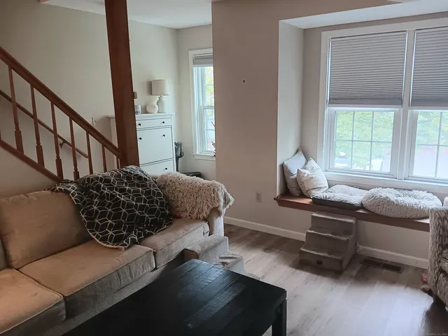 a living room with a bed furniture and a window